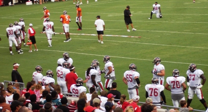 Line drills in foreground, offensive skill position drills in background. 