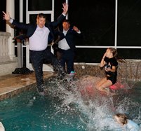 Bucs director of player personnel Jon Robinson, left, joins Bucs GM Jason Licht and Licht's children in the traditional victory--postgame-plunge-with-the-suits-on last night.