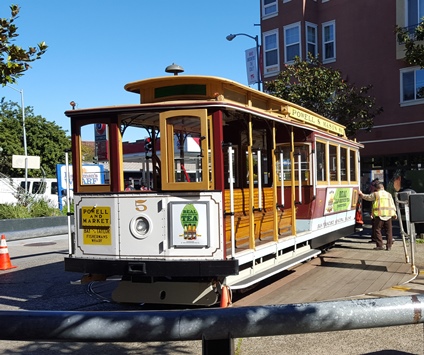 A San Francisco icon, a cable car, which when it hits the end of the line, has to be manually turned by around an attendant for the return trip. 